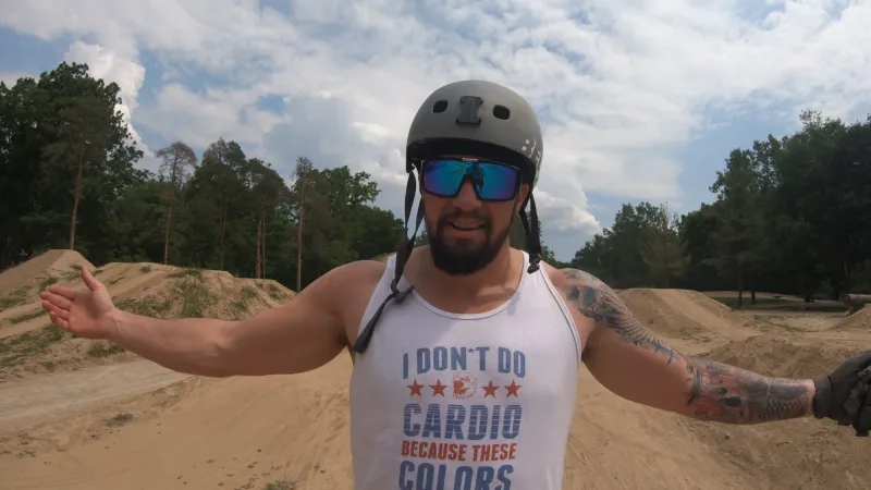 Josh at a dirt jump park in an I don't do cardio tank